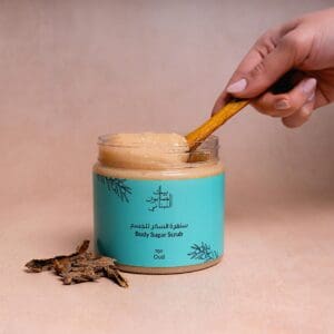 Naturally luxurious Oud Body Sugar Scrub by House of Soap being scooped out by a wooden tool